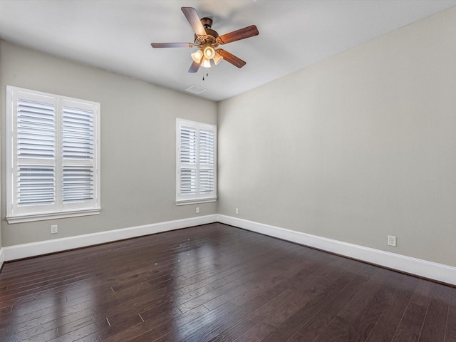 unfurnished room with ceiling fan, baseboards, dark wood-type flooring, and visible vents