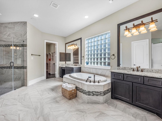 full bathroom with a garden tub, a stall shower, a walk in closet, two vanities, and visible vents