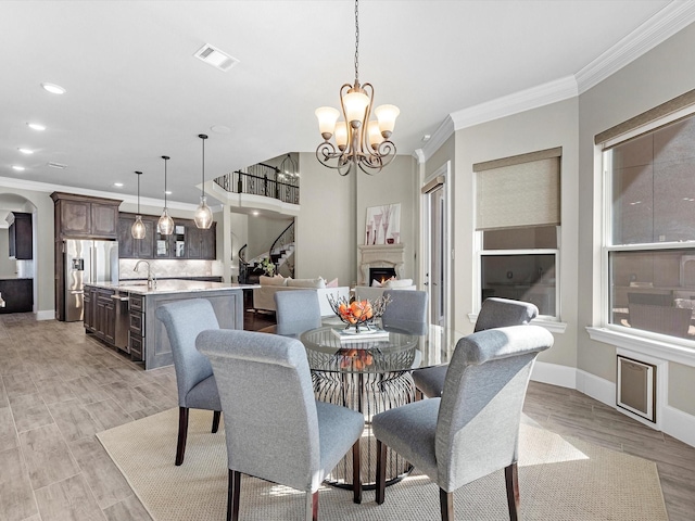 dining space featuring recessed lighting, ornamental molding, light wood finished floors, visible vents, and a chandelier