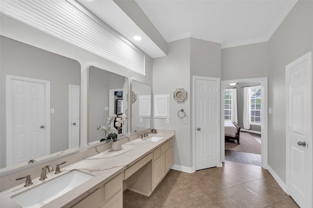 ensuite bathroom with tile patterned floors, baseboards, ornamental molding, double vanity, and recessed lighting