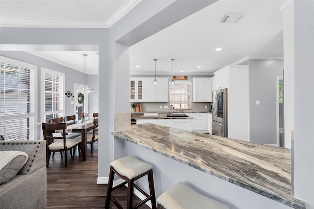 kitchen with smart refrigerator, dark wood finished floors, a breakfast bar area, ornamental molding, and white cabinets
