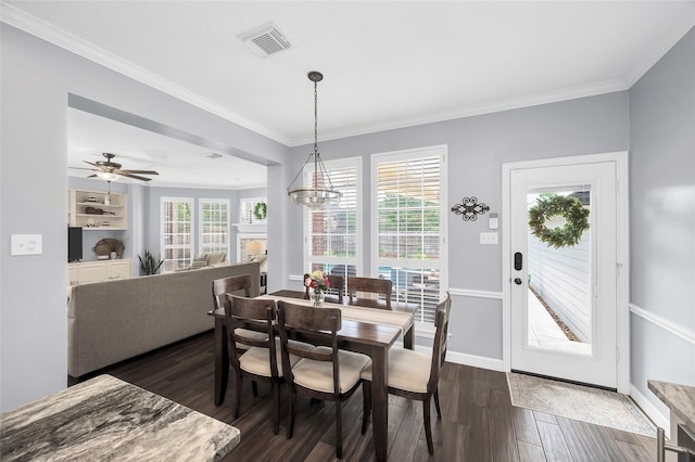 dining room featuring dark wood finished floors, ornamental molding, baseboards, a chandelier, and ceiling fan