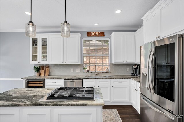 kitchen featuring stainless steel appliances, wine cooler, white cabinets, tasteful backsplash, and a kitchen island