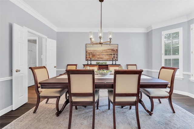 dining room featuring wood finished floors, baseboards, ornamental molding, and a chandelier