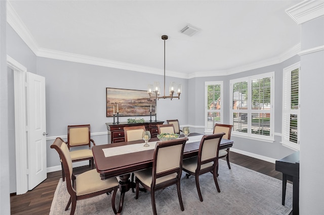 dining space featuring dark wood-style flooring, crown molding, a chandelier, and baseboards