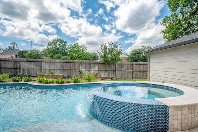 view of pool with fence and a pool with connected hot tub