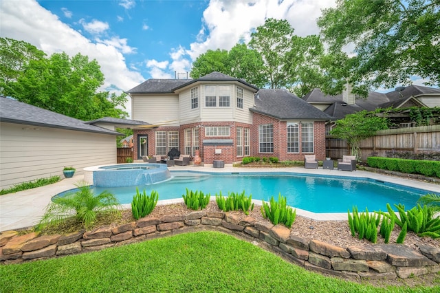 view of swimming pool with fence, a pool with connected hot tub, and a patio area