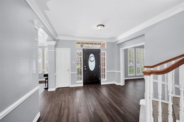 foyer with wood finished floors, baseboards, crown molding, and stairway