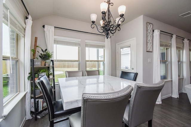 dining space with an inviting chandelier, dark wood finished floors, visible vents, baseboards, and vaulted ceiling
