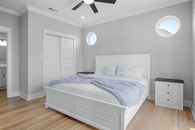 bedroom featuring ornamental molding, light wood-style flooring, visible vents, and multiple windows