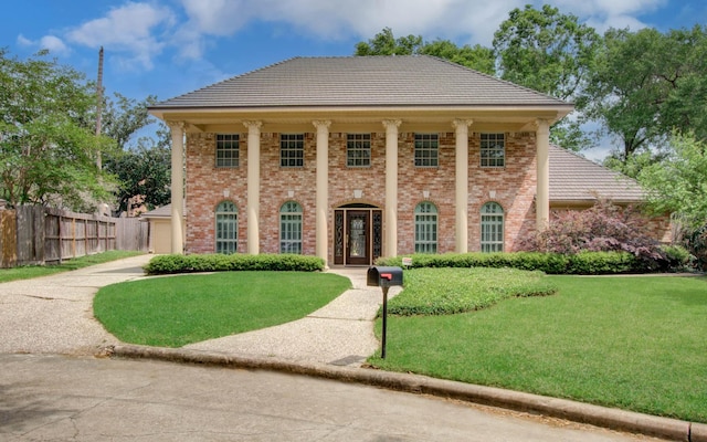 11022 Riverview Dr, Houston, TX 77042 - view of front of home with brick siding, a tile roof, fence, and a front yard