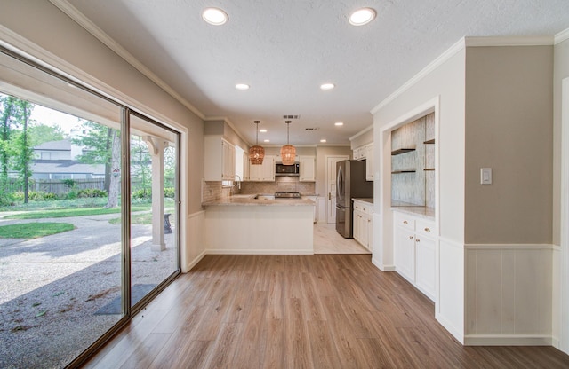 11022 Riverview Dr, Houston, TX 77042 - kitchen with a peninsula, light wood-style flooring, light countertops, appliances with stainless steel finishes, and ornamental molding