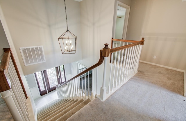 11022 Riverview Dr, Houston, TX 77042 - stairs with an inviting chandelier, visible vents, baseboards, and carpet floors