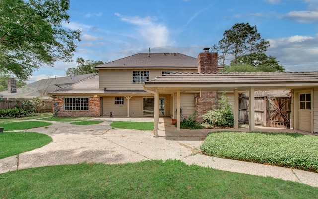 11022 Riverview Dr, Houston, TX 77042 - rear view of property featuring a chimney, a lawn, brick siding, fence, and a patio area