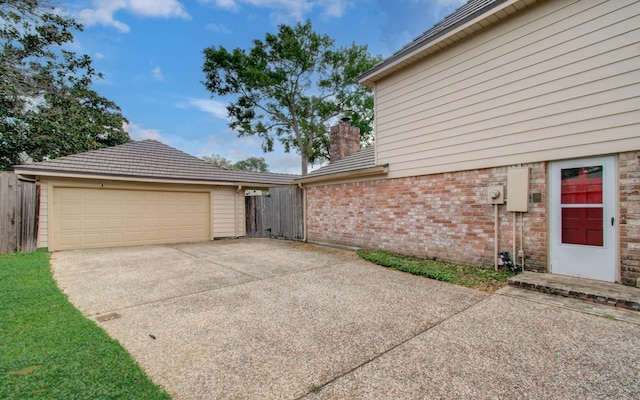 11022 Riverview Dr, Houston, TX 77042 - view of side of home featuring concrete driveway, brick siding, fence, and a chimney