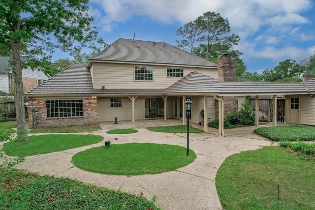 11022 Riverview Dr, Houston, TX 77042 - back of property featuring a chimney, fence, a yard, brick siding, and a patio area