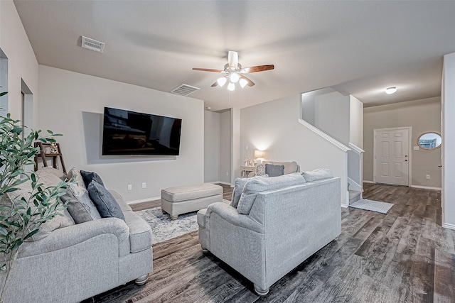 living area with stairway, dark wood-style flooring, a ceiling fan, and visible vents