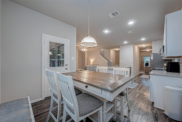 dining area featuring baseboards, visible vents, and dark wood-style floors