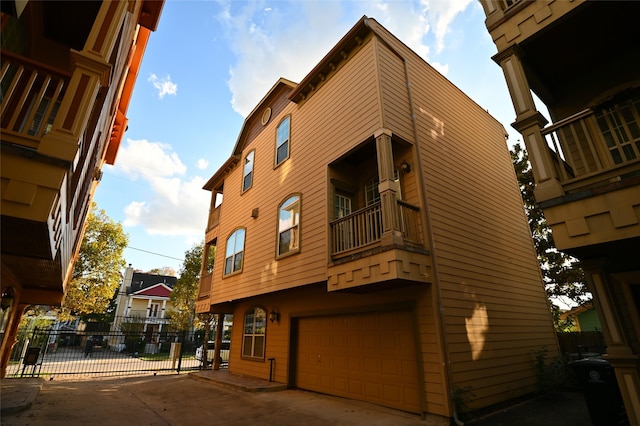 view of property featuring concrete driveway, fence, and a garage