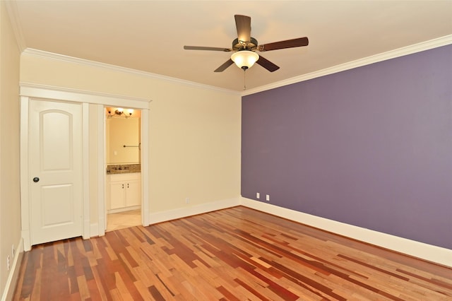 unfurnished bedroom with baseboards, ensuite bathroom, ceiling fan, crown molding, and wood finished floors