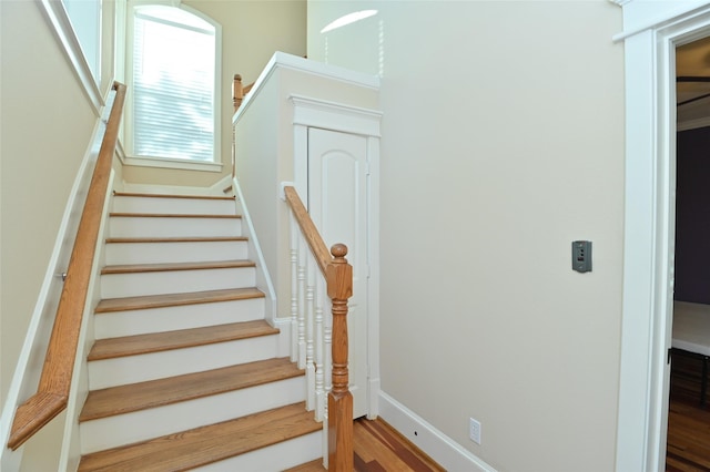 stairway with baseboards and wood finished floors