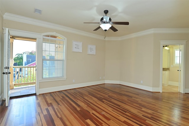 empty room with a ceiling fan, crown molding, visible vents, and wood finished floors