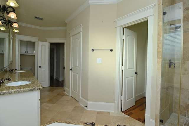 bathroom featuring a shower stall, ornamental molding, visible vents, and a sink