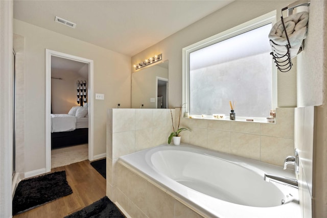 3730 Giorgio Pastel Pl, Katy, TX 77493 - ensuite bathroom featuring baseboards, ensuite bath, visible vents, a bath, and wood finished floors