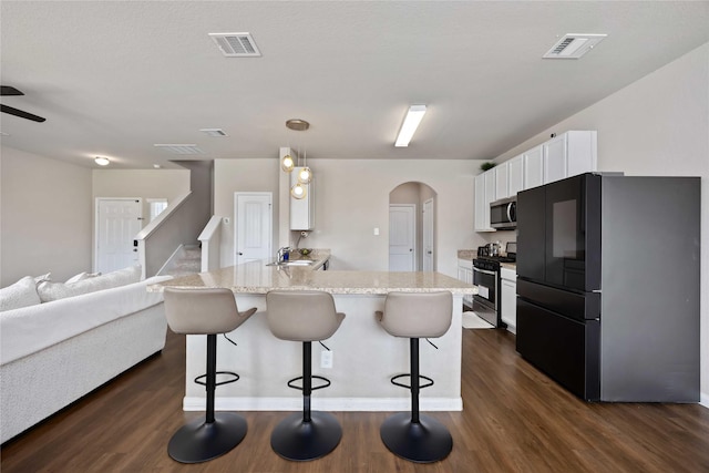 3730 Giorgio Pastel Pl, Katy, TX 77493 - kitchen featuring arched walkways, stainless steel appliances, a peninsula, and visible vents