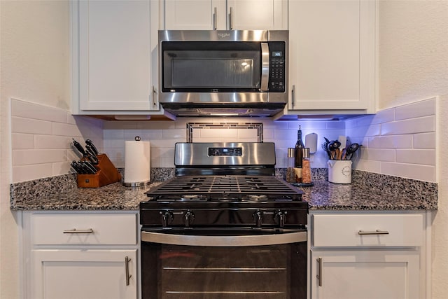 9705 Wall St, Texas City, TX 77591 - kitchen featuring stainless steel microwave, dark stone counters, gas stove, white cabinetry, and decorative backsplash