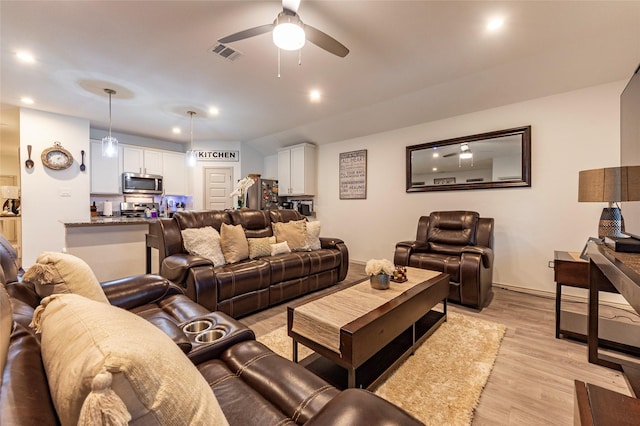 9705 Wall St, Texas City, TX 77591 - living room featuring baseboards, visible vents, light wood-style flooring, and a ceiling fan