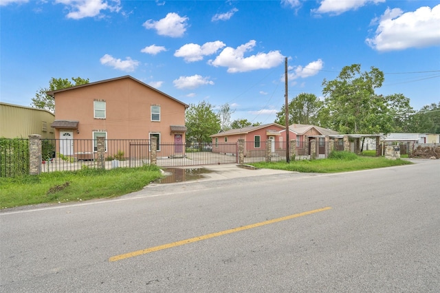 view of front of home featuring stucco siding, a fenced front yard, and a gate