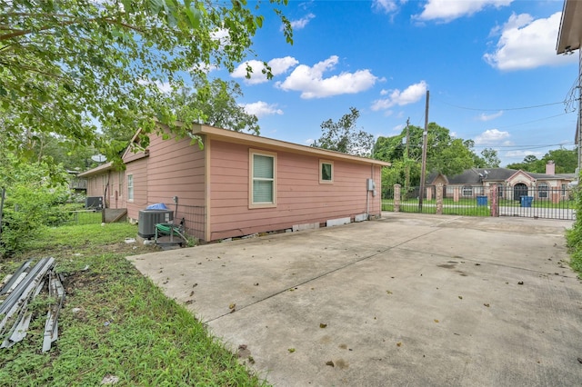 back of house featuring central air condition unit, fence, a patio area, and driveway