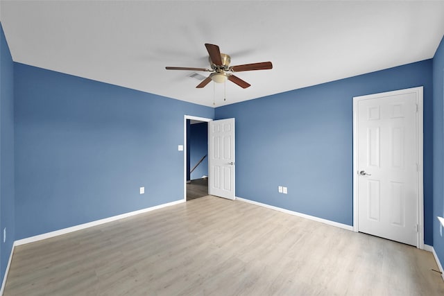 unfurnished bedroom with visible vents, wood finished floors, baseboards, and ceiling fan