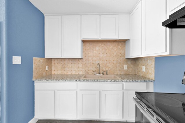 kitchen with under cabinet range hood, stainless steel electric range, a sink, backsplash, and white cabinets