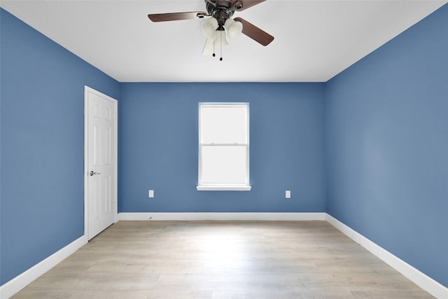 empty room featuring light wood-style floors, baseboards, and a ceiling fan