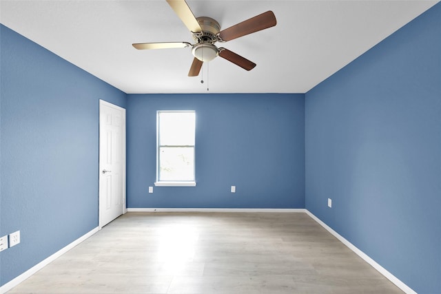 empty room with baseboards, ceiling fan, and light wood-type flooring
