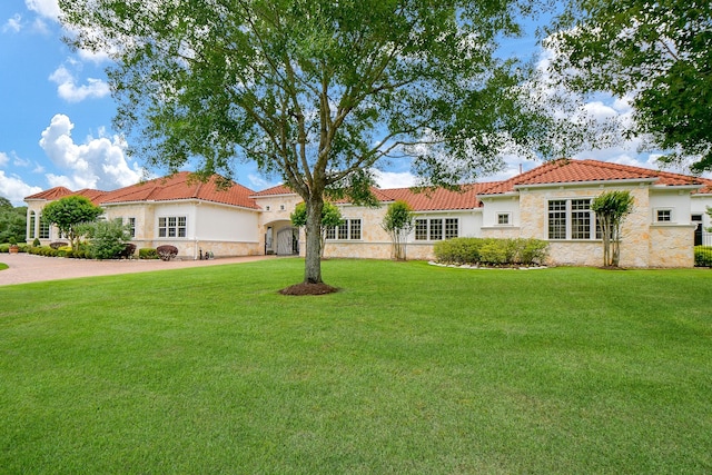 2718 Silverhorn Dr, Katy, TX 77450 - mediterranean / spanish house with a tile roof, a front lawn, stucco siding, and stone siding