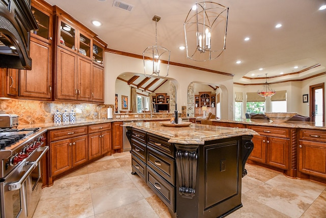 2718 Silverhorn Dr, Katy, TX 77450 - kitchen featuring arched walkways, appliances with stainless steel finishes, ornamental molding, light stone counters, and decorative backsplash