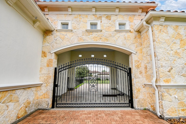 2718 Silverhorn Dr, Katy, TX 77450 - view of exterior entry with stone siding, a gate, and stucco siding