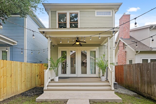 rear view of property featuring french doors, ceiling fan, and a fenced backyard