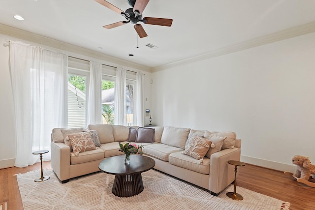 living room with crown molding, light wood-type flooring, ceiling fan, baseboards, and recessed lighting