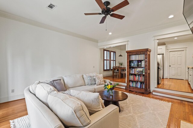 living area with ceiling fan, ornamental molding, light wood finished floors, recessed lighting, and baseboards