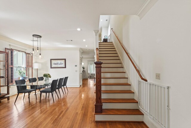 staircase featuring ornamental molding, wood finished floors, baseboards, and recessed lighting