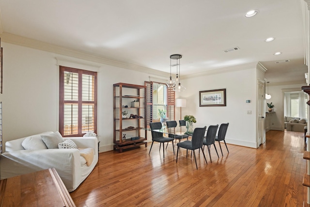 dining area featuring ornamental molding, healthy amount of natural light, light wood-style floors, recessed lighting, and baseboards