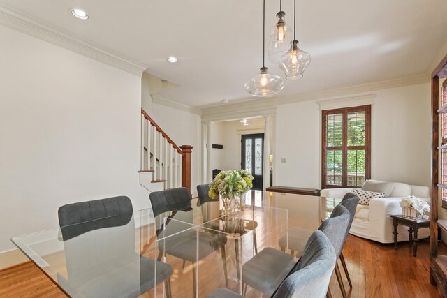 dining space featuring stairs, ornamental molding, wood finished floors, recessed lighting, and ornate columns