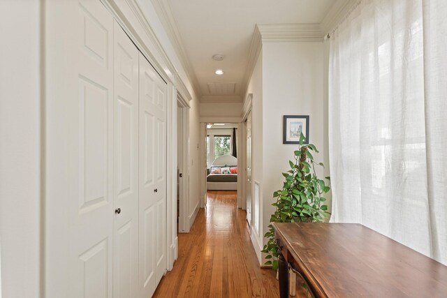 hall with crown molding, light wood-style flooring, baseboards, and recessed lighting