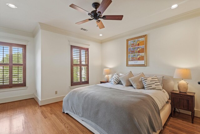 bedroom featuring multiple windows, baseboards, light wood-style flooring, crown molding, and recessed lighting