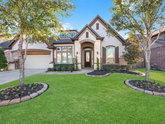 french provincial home featuring brick siding, a front yard, concrete driveway, and a garage