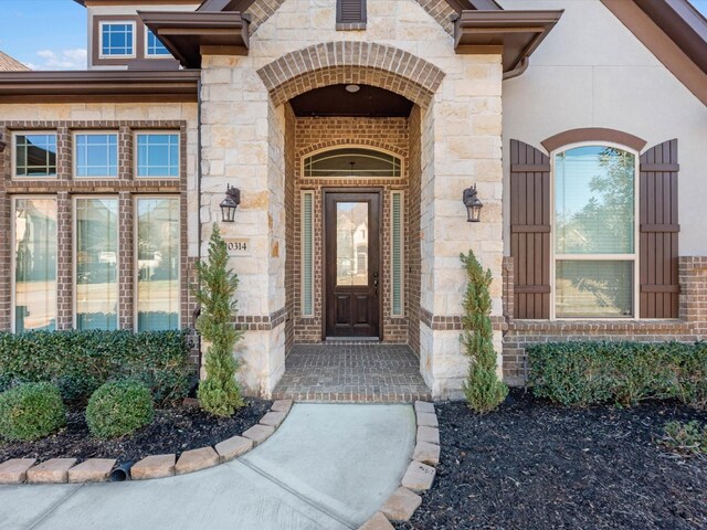 property entrance with stone siding and brick siding